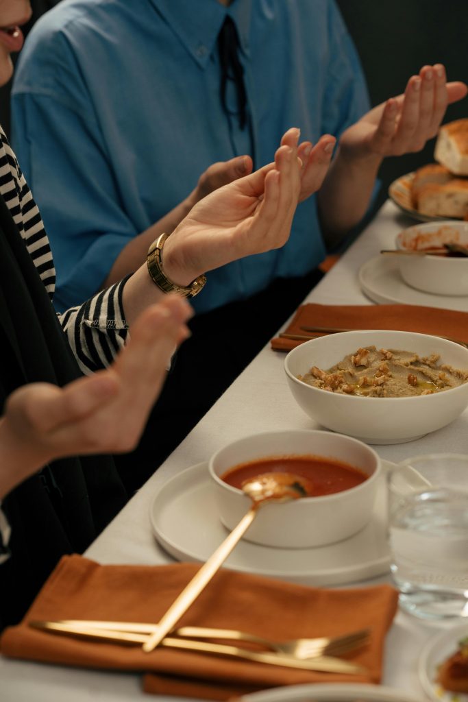 People praying before a meal during Ramadan, symbolizing cultural and religious traditions.